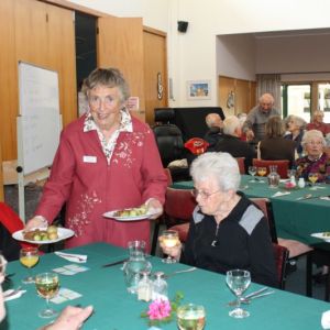 Chaplain Jan Gough heps serve dinner.JPG