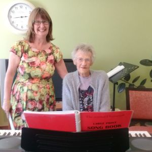 Diversional Therapis Bernadette Waller listens to 100 year old Gwen play the piano.ay
